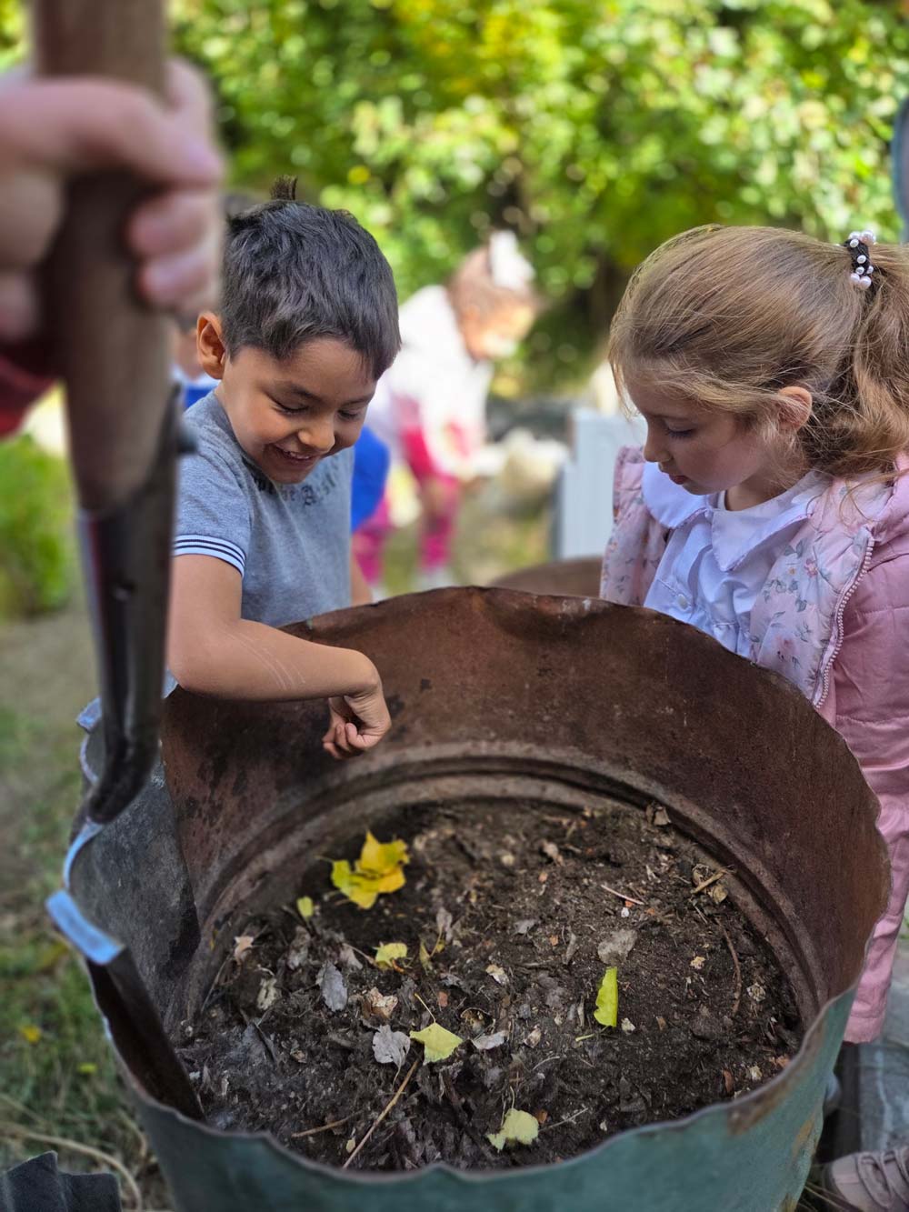 Two kids participatining in a composting workshop