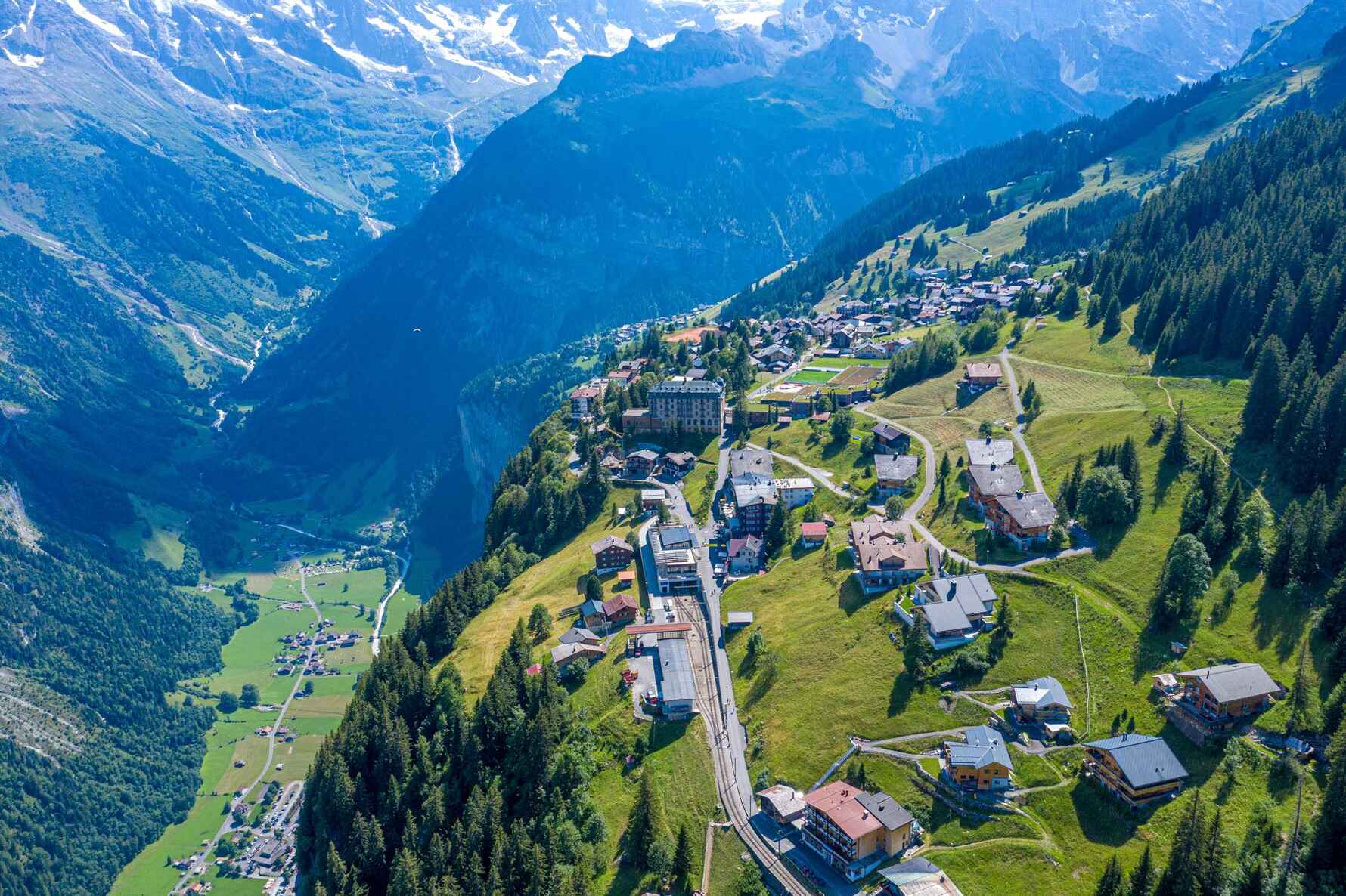 View of Wengen village perched high on the mountain with the Lauterbrunnen valley below