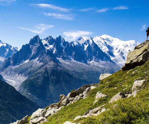 A trekker looking at a stunning view of Mont Blanc